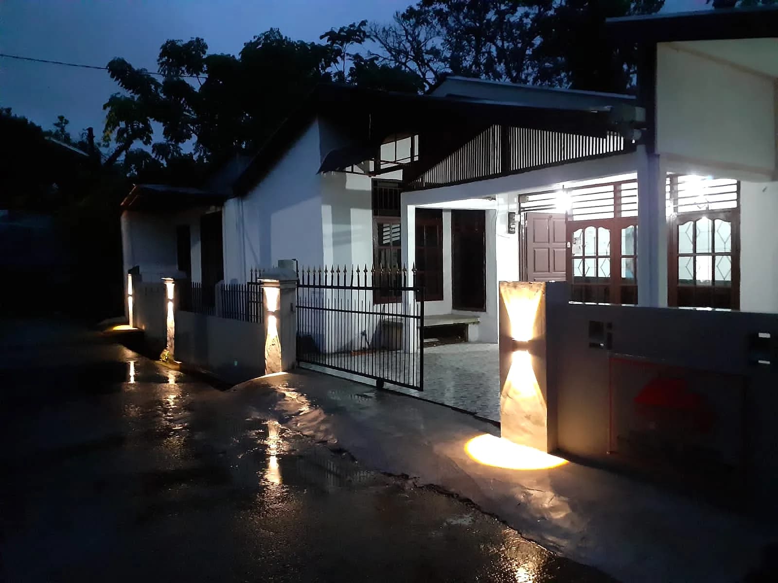 Rumah hasil pengerjaan tim barumahID di malam hari, lampu pilar pagar menyala